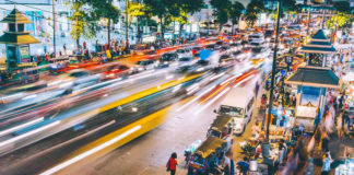 A time-lapsed scene of a busy street at night in Bangkok, Thailand.