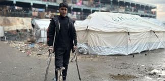 © UNRWA Ένας νεαρός στέκεται κοντά σε προσωρινά καταλύματα στη Γάζα.