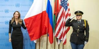 Vanessa Frazier (left), Permanent Representative of Malta to the United Nations, stands next to the flag of her country at the Installation Ceremony of Non-Permanent Members of Security Council for 2023-2024.