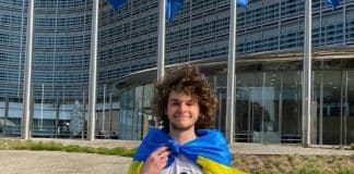 Ukrainian student holding Ukrainian flag in front of Berlaymint