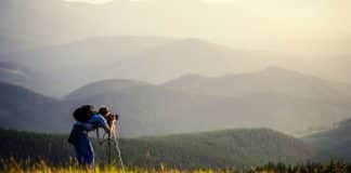 Man taking photographs in hilly landscape