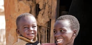 A child holding a smaller child, both happy