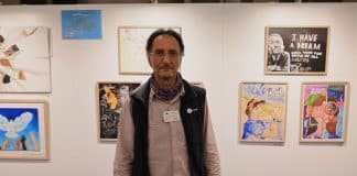 Doros Polykarpou standing in front of a Human Rights exhibit at the European Parliament