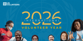 Volunteers standing together with International Volunteer Year 2026 in the background