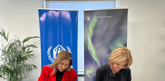 Two women signing papers