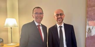 Two men in suits smiling to the camera