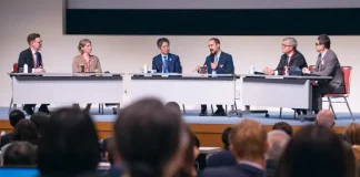 A meeting room with a panel speaking
