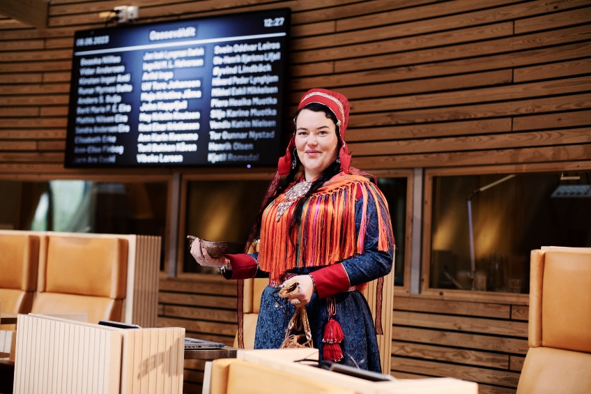 A woman in traditional Sami clothing in a formal setting