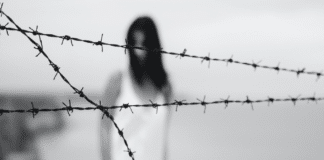 Mujer detras de alambre de púas