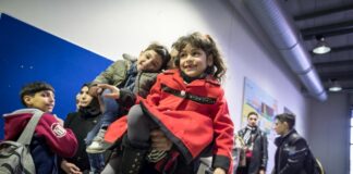 Un hombre sirio espera en la línea, junto a su hija e hijo en el aeropuerto de Hanover