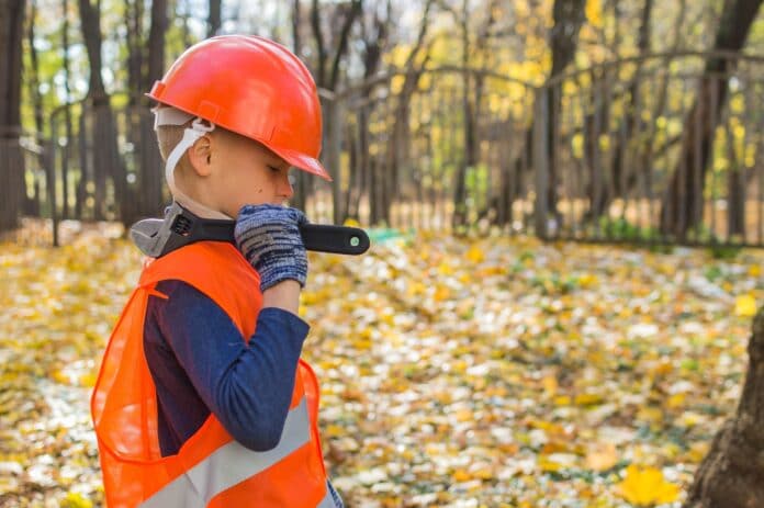 niño vestido de obrero con casco y llave inglesa
