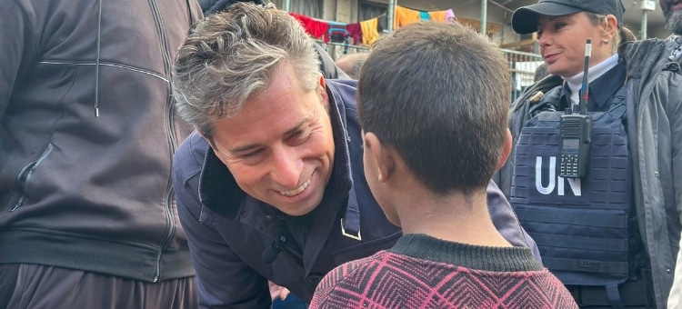 K:n avustuspäällikkö Tom Fletcher keskustelee lapsen kanssa UNRWA:n suojapaikassa Gazassa helmikuussa. Kuva: © UNOCHA/Olga Cherevko