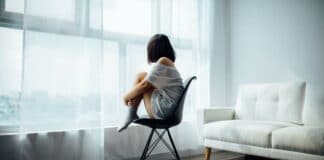 femme recroquevillée regardant fenêtre