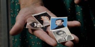 Kona heldur á mynd af manni sínum og tveimur bræðrum sem myrtir voru í Srebrenica