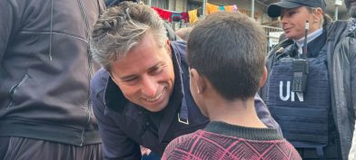 Tom Fletcher talar við barn sem dvelst í skýli á vegum UNRWA í vettvangsferð til Gasasvæðisins.