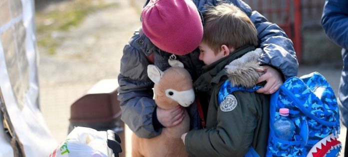 Ukraine children (1) Úkraíns stúlka huggar litla bróður sinn í miðstöð UNICEF í Rúmeníu. Mynd: UNICEF/Alex Nicodim