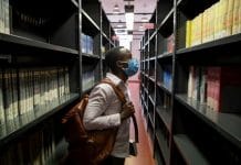 Jules, a 26-year-old student from the Democratic Republic of the Congo, scans the shelves of the social science library at the University of Florence
