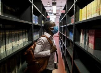 Jules, a 26-year-old student from the Democratic Republic of the Congo, scans the shelves of the social science library at the University of Florence