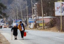 Mila Volodymyrivna Khalova, Kyiv, with assistance from a volunteer, heads to the Slovak border