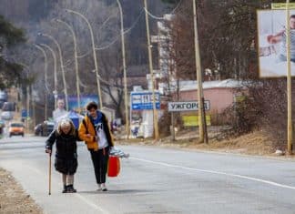 Mila Volodymyrivna Khalova, Kyiv, with assistance from a volunteer, heads to the Slovak border