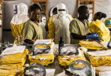 Gli operatori sanitari indossano dispositivi di protezione individuale (DPI) prima di entrare in una zona di quarantena Ebola nella Repubblica Democratica del Congo.