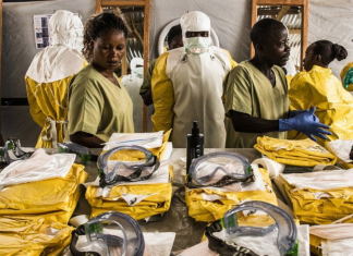 Gli operatori sanitari indossano dispositivi di protezione individuale (DPI) prima di entrare in una zona di quarantena Ebola nella Repubblica Democratica del Congo.
