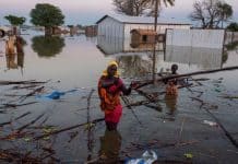 una donna e un bambino sudsudanesi cercano di recuperare i propri averi dopo un alluvione