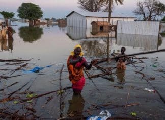 una donna e un bambino sudsudanesi cercano di recuperare i propri averi dopo un alluvione