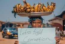 Manifestante in Ghana mostra cartello contro la corruzione