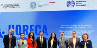 L’OIL e AICS uniscono le forze per rafforzare l’occupazione giovanile nel settore dell’ospitalità in Kosovo Foto di gruppo durante un evento ufficiale del progetto HORECA, con rappresentanti dell'Agenzia Italiana per la Cooperazione allo Sviluppo, dell'Ambasciata d’Italia a Pristina e dell’Organizzazione Internazionale del Lavoro, davanti a uno schermo che promuove l'integrazione dei giovani nel mercato del lavoro del settore dell’ospitalità