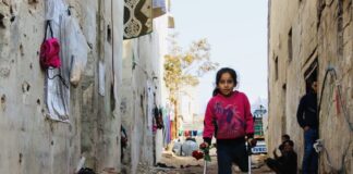 Flicka med ett ben på kryckor i Syrien