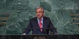 FNs generalsekreterare António Guterres står i en talarstol iklädd kostym och slips