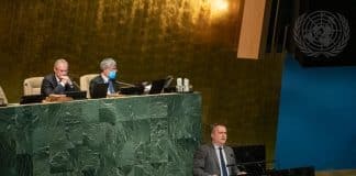 En man som talar vid en talarstol inför ett plenum