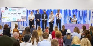 Fem ungdomar som står framför en publik