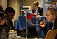 Ungdomar, en vid ett podium och andra diskuterar i grupp
