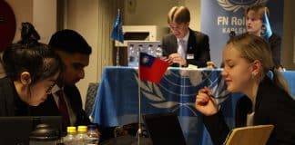 Ungdomar, en vid ett podium och andra diskuterar i grupp