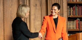 Två kvinnor som skakar hand under ett officiellt tillfälle