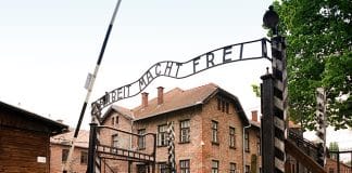 En stor byggnad med texten Arbeit Macht Frei ovanför ingången
