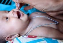 En baby som får flytande vaccin genom munnen