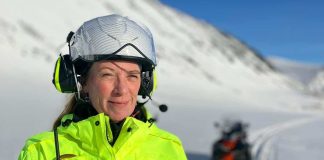En kvinna i hjälm med istoppar i bakgrunden