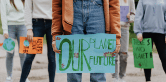 En person som håller en skylt med orden Our planet our future