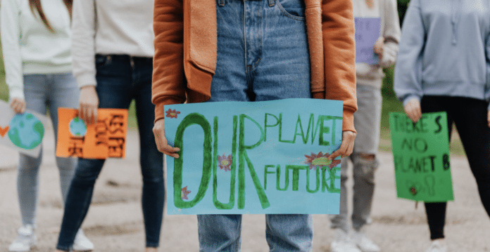 En person som håller en skylt med orden Our planet our future