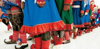 En grupp samer utomhus i traditionell klädsel