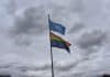 Två hissade flaggor, en för FN och en regnbågsflagga