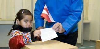 En flicka som håller en flagga och en person som röstar