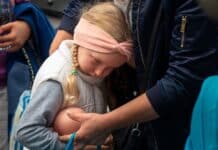 En flicka som lutar sig mot en annan person