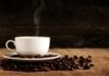 En rykande kaffekopp och kaffebönor