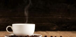 En rykande kaffekopp och kaffebönor