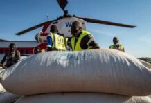 Hjälparbetare i förgrunden och en helikopter i bakgrunden