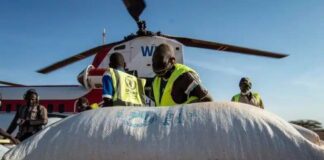 Hjälparbetare i förgrunden och en helikopter i bakgrunden